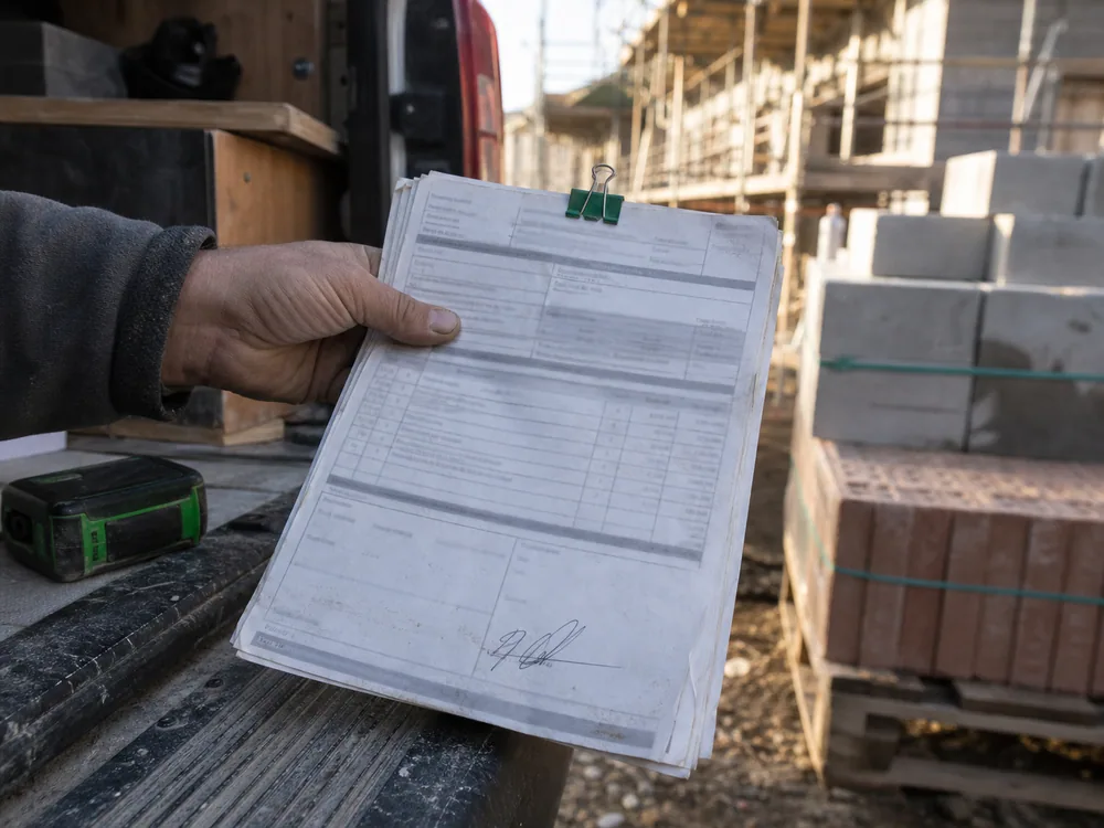 A signed packing slip clipped to its matching order on a work van tailgate.